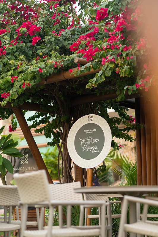 Pergolada florida do restaurante Beijupirá Olinda na Villa Muro Alto, com mesas ao ar livre sob buganvílias.